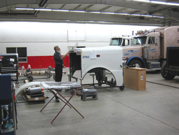 A technician at Peterbilt of Northwest Ohio repairs a semi-truck hood assembly. 
