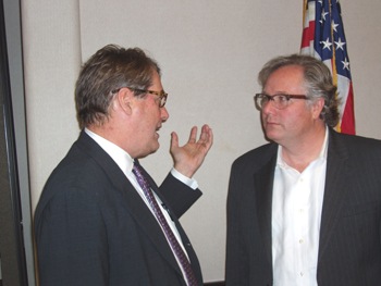 Attorney John Eaves Jr. (right) speaks with an attendee at the meeting.