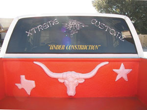 one of harris’s custom sprayed-on bedliner jobs: the texas longhorns’ logo and colors on a gmc half-ton fleet side 4x4 extended cab shortbed dually.