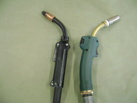(left to right) steel mig welding torch and aluminum torch. (note wire speed adjustment wheel opposite trigger).