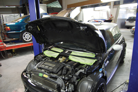 a car being prepped for the repair process at clean green collision has its cowl vents taped up to prevent contamination of the interior with paint residue.