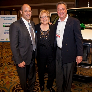 Howard Putterman (left) of Enterprise Rent-A-Car and Tom Csekme of Gerber Collision stand with Terry Lindemann, executive director of Family Promise of Las Vegas, in front of the donated 15-passenger van at the SEMA Show. 