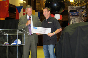 sherwin-williams chairman and ceo chris connor hands greg biffle a check for $1,600 for the greg biffle foundation.