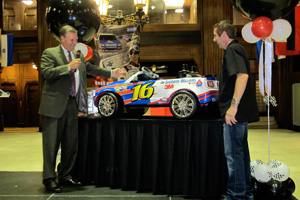 sherwin-williams chairman and ceo chris connor presents a toy car to greg biffle for his newborn daughter to drive some day soon.